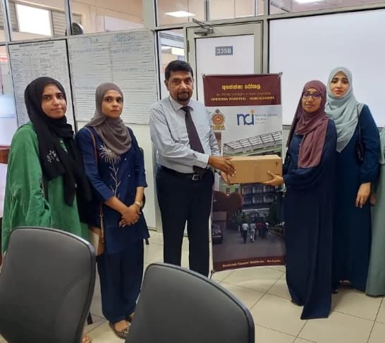 Dr. Jaliya Jayasekara receiving a vial donation from the IIOGA team at Apeksha Hospital